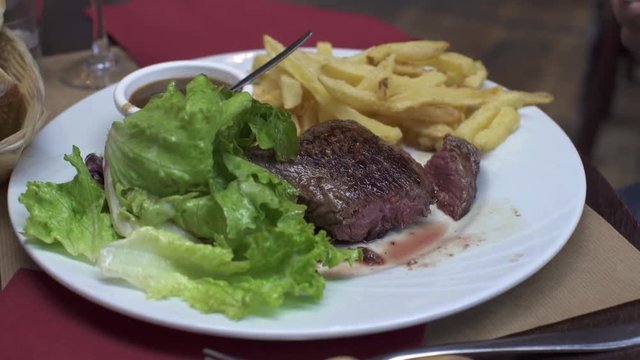 PARIS, FRANCE  &ndash; SEPTEMBER 2016 : Video shot of cutting steak in a local french restaurant