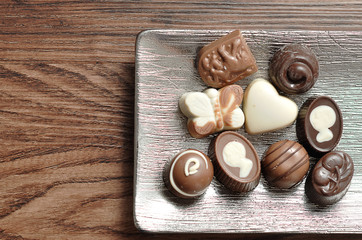 A variety of small chocolates displayed on a silver tray