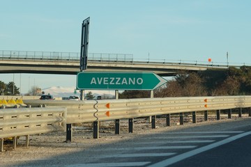 Highway green sign to Avezzano. Avezzano is a city and comune, situated in the Abruzzo region,...