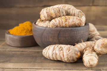 Roots and turmeric powder on the table - Curcuma longa