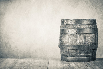 Classic old retro aged oak barrel with hoops on wooden floor front concrete wall background....