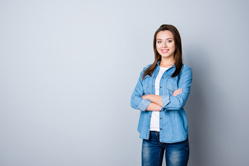 Portrait of caucasion successful, pretty, cute busnesswoman in casual outfit, standing over grey background with copy space, having her hand crossed