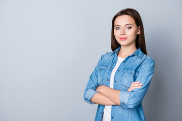 Portrait of caucasion successful, pretty businesswoman in casual outfit, standing over grey background with copy space, having her hand crossed