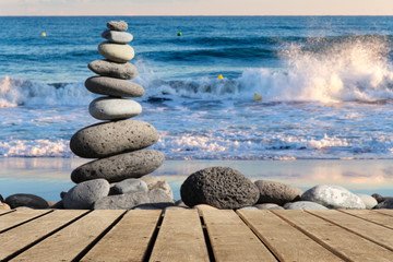 Holzboden leer mit gestapelten Steinen am Strand