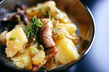 Baked potatoes, meat and greens close-up on a plate