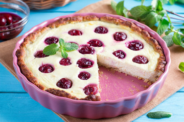 Cherry open pie with cottage cheese and sour cream filling, in baking form