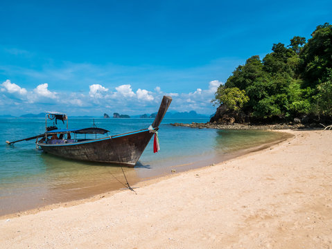 Long thail boat on the beach of an empty island Koh Nok in Thailand.