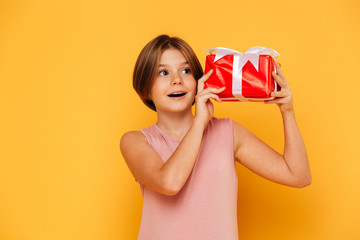 Little girl holding gift and looking aside