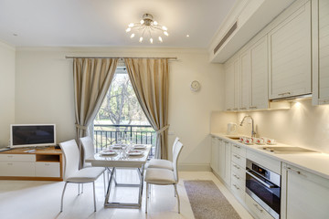 Interior of a cozy living room in light colours with kitchen in a private studio