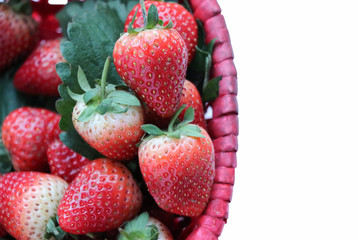 Red strawberries in red basket on white background