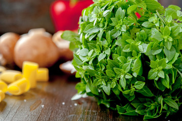 Green basil leaves on a dark kitchen table.