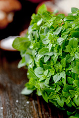 Green basil leaves on a dark kitchen table.