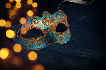Image of elegant blue and gold venetian, mardi gras mask over black background.