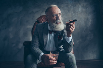 Minded, ponder rich man in glasses, smoke cigarette, fume, hold glass with brandy, in tux with red...