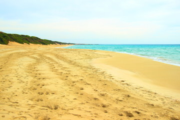 Fototapeta na wymiar Footprints on beautiful sandy beach in Puglia, Italy