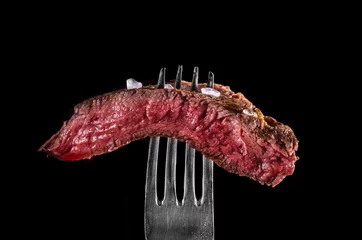 Abwaschbare Fototapete Fleish Rindfleisch selten auf schwarzem Hintergrund der Gabel