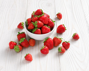 Strawberry in bowl on white wooden table. Close up. High resolution product. Harvest Concept