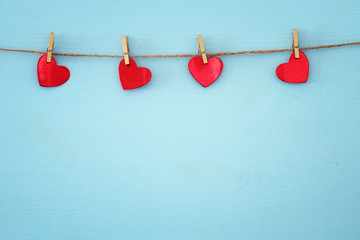 Valentine's day background. hearts hanging in front of wooden background.