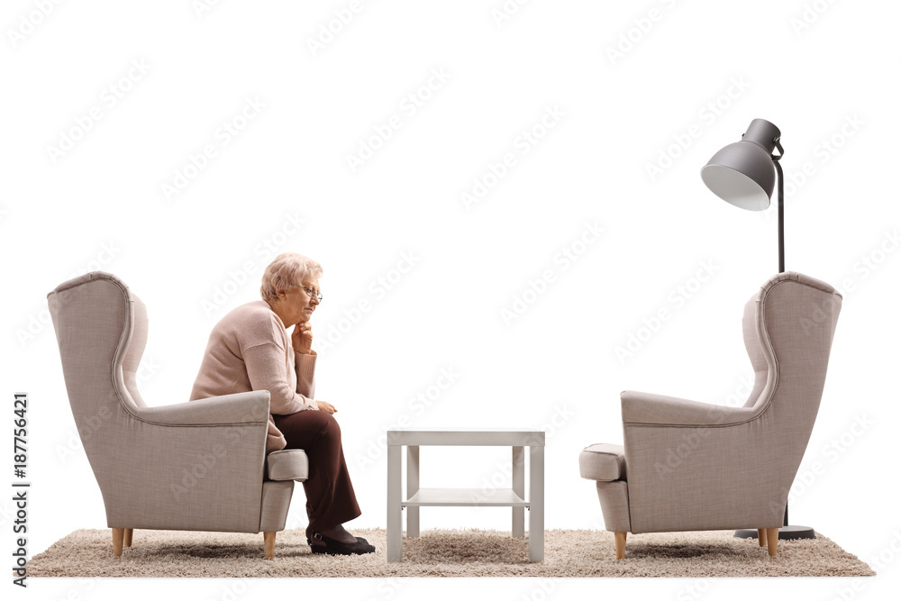 Wall mural depressed and lonely mature woman sitting in an armchair