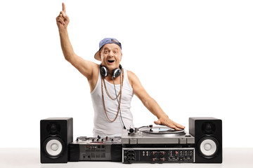 Cheerful old DJ playing music on  a turntable and holding his finger up