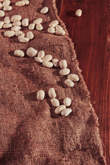 Fototapeta na wymiar Navy bean or White bean on wooden background on burlap