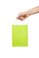woman hand holds a bright green bag for shopping isolated on white background