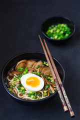 Ramen soup with mushrooms, vertical, black background