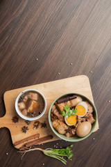 Pha-lo : Eggs boiled and pork boiled with spices  and fried tofu in sweet gravy soup on wooden background with copy space