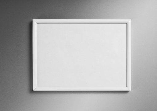 White frame for paintings or photographs on gray background.