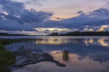 Picturesque sunset on the lake in Finland in blue and violet colors