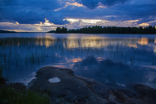 Picturesque sunset on the lake in Finland in blue colors