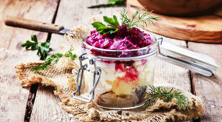 Traditional Russian salad herring under a fur coat, vintage wood background, selective focus