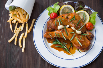 Prepare grill chicken steak on white dish and ingredient, sliced lemon, pepper in glass bowl and vegetable on glass bowl at the kitchen, Dim light
