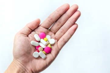 Top view of the pills on the hand and white background, A hand hold the pills and drug, Pile of the drug and pills on the hand.