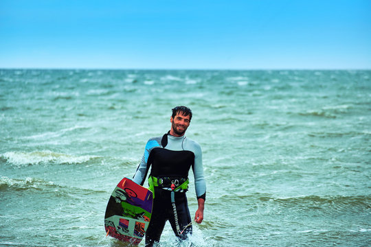 Man riding a kite surfing on the waves in the summer.