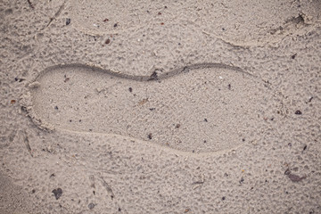 Fototapeta na wymiar imprinted footprints on the wet sand, close up
