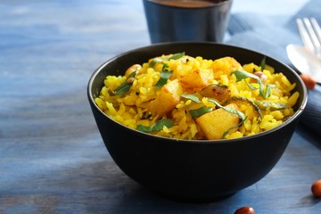 Batata Poha / Indian breakfast with potatoes and flattened rice, selective focus