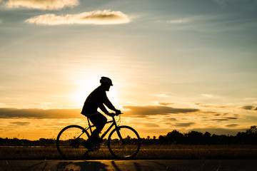 Obraz premium Silhouette man cycling at sunset