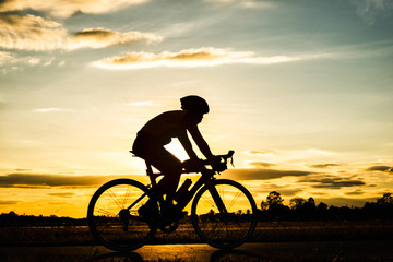 Obraz premium Silhouette man cycling at sunset