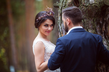 bride looks playfully at groom near tree