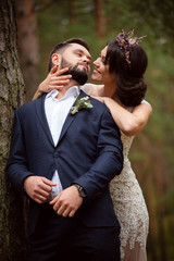 bride smiles and hugs  groom from back