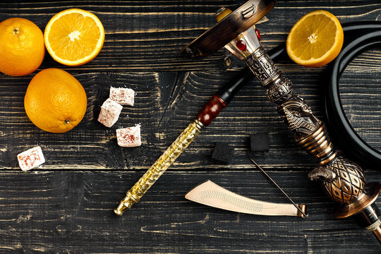 Dismantled parts of hookah on a wooden background with orange fr