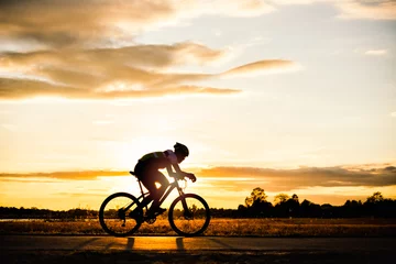  Silhouette man cycling at sunset © songdech17
