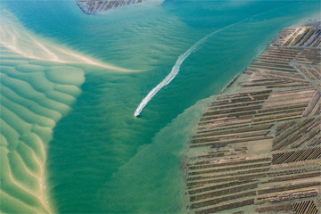 Vue aérienne d'un bateau et de parcs à huitres dans le Bassin d'Arcachon en France