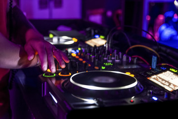 Fototapeta na wymiar dj mezclando en discoteca fiesta de techno luces de colores botones y plato