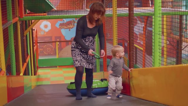 Top veiw of mother and toddler climbing slide and dagging tube