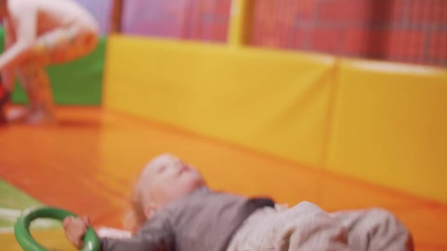 Little blond boy dags tube and falls down laughing