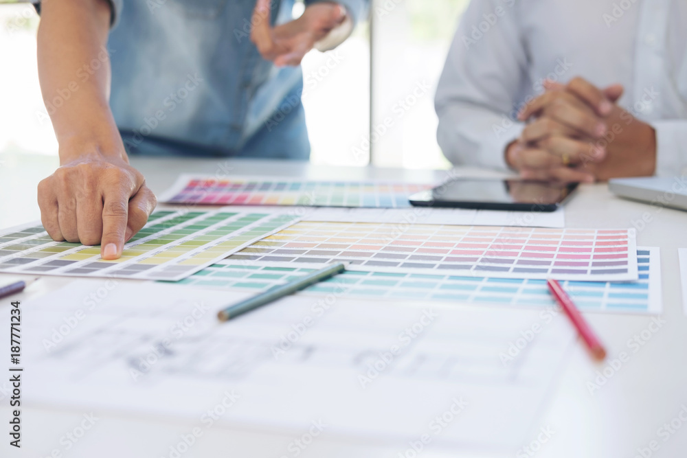 Aufkleber Two interior design or graphic designer at work on project of architecture drawing with work tools and color swatches, colour chart, color samples for selection, renovation and technology concept