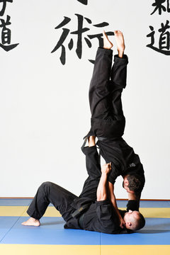 Fighting position of Judo and Ju-jitsu called Tomoe Nage between Ju-jitsu GI and 1st Dan Obi