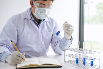 Scientist or medical in lab coat holding test tube with reagent, Laboratory glassware containing chemical liquid, Biochemistry laboratory research